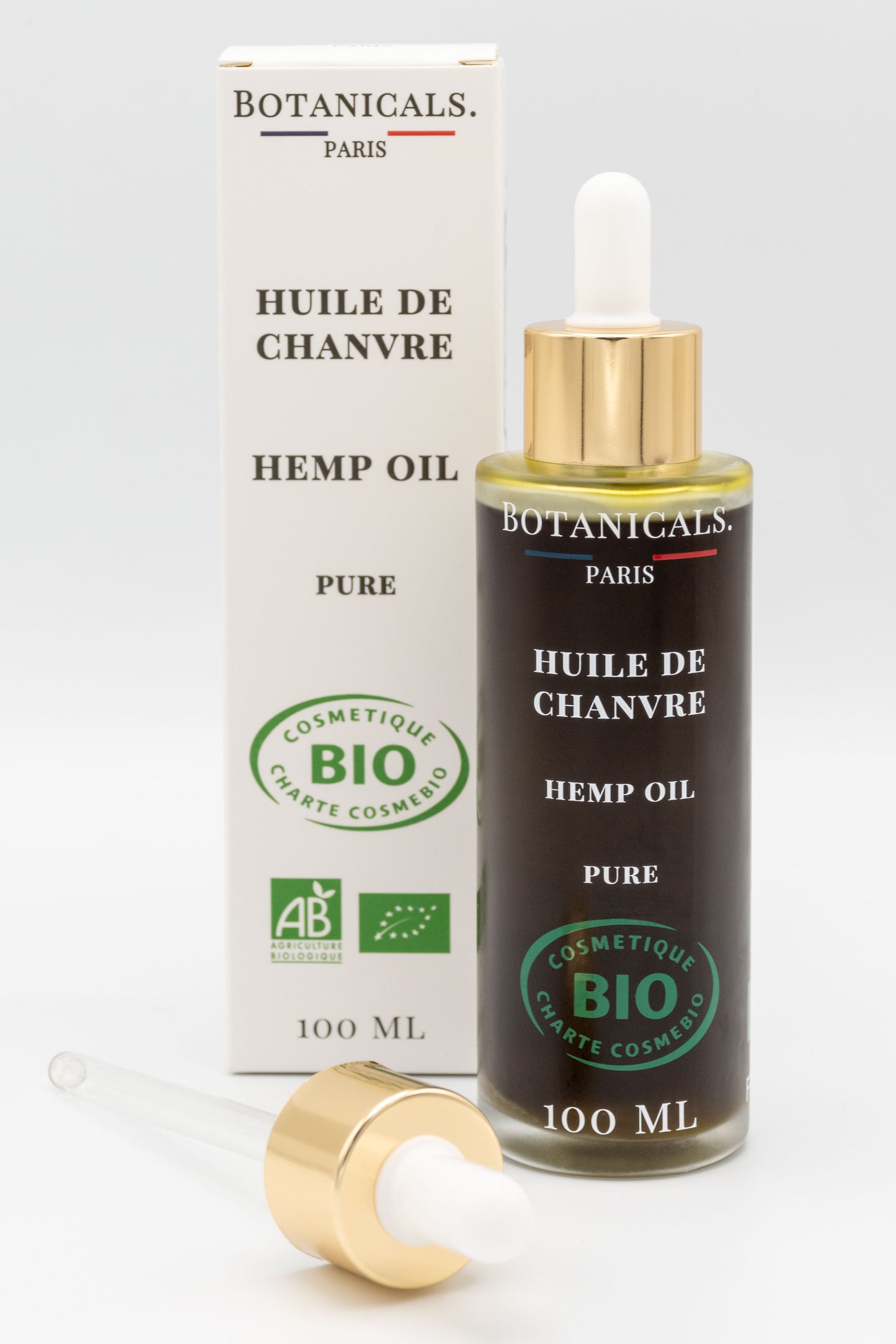 Une bouteille d'huile de chanvre bio 100ml Botanicals devant sa boite, une pipette posé devant