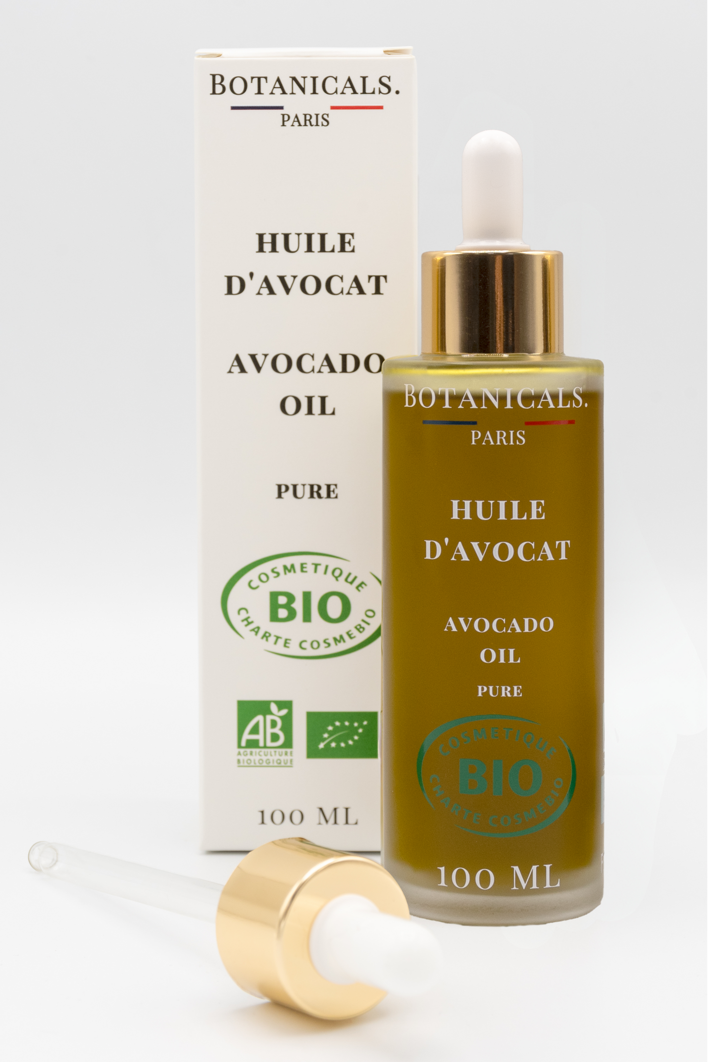 Une bouteille d'huile d'avocat bio 100ml Botanicals devant sa boite, une pipette posé devant