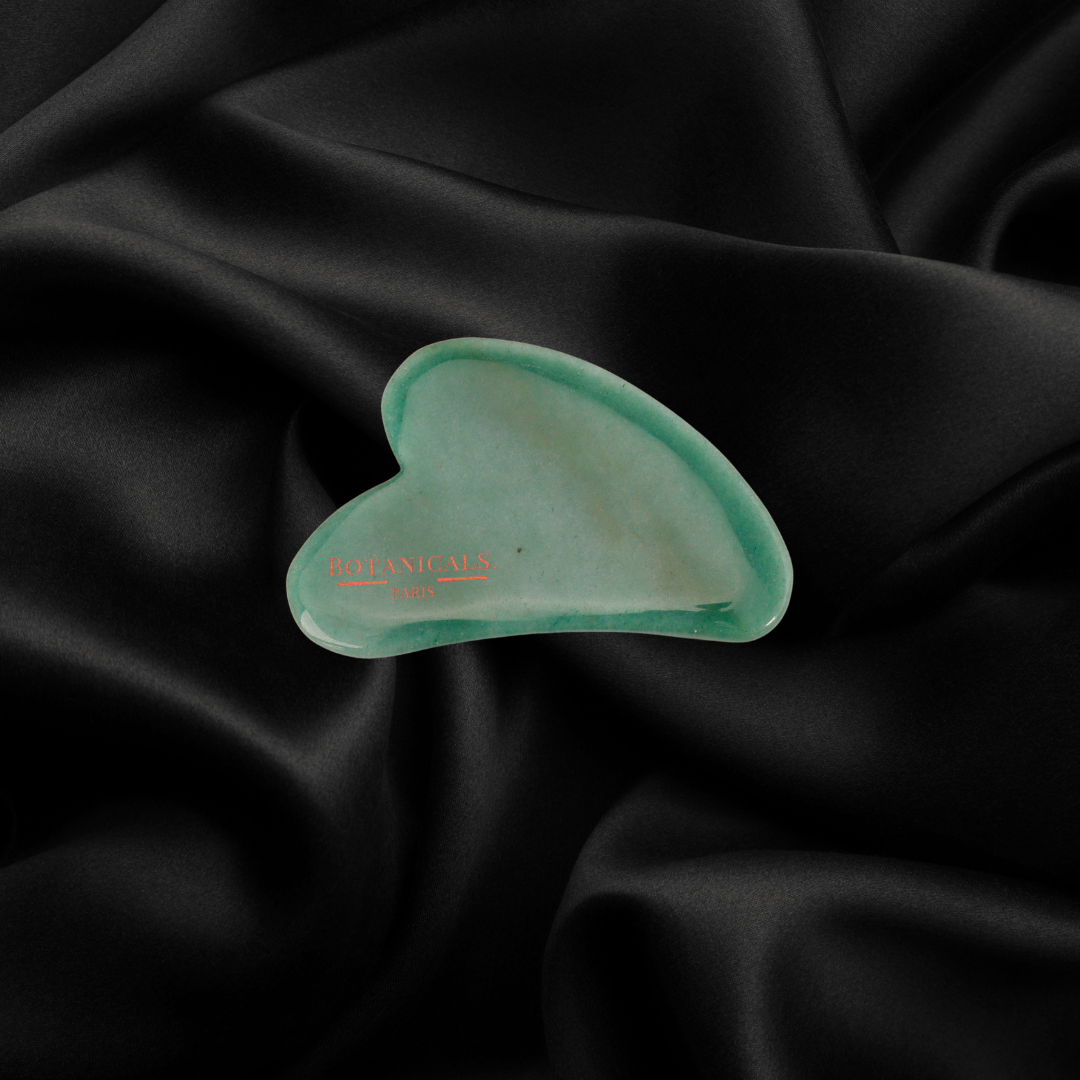 Guasha Botanicals en Jade devant un fond en soie de murier noir