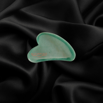 Guasha Botanicals en Jade devant un fond en soie de murier noir