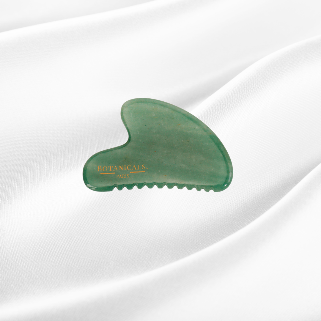 Guasha à dents Botanicals en Jade sur un fond de soie de mûrier blanc