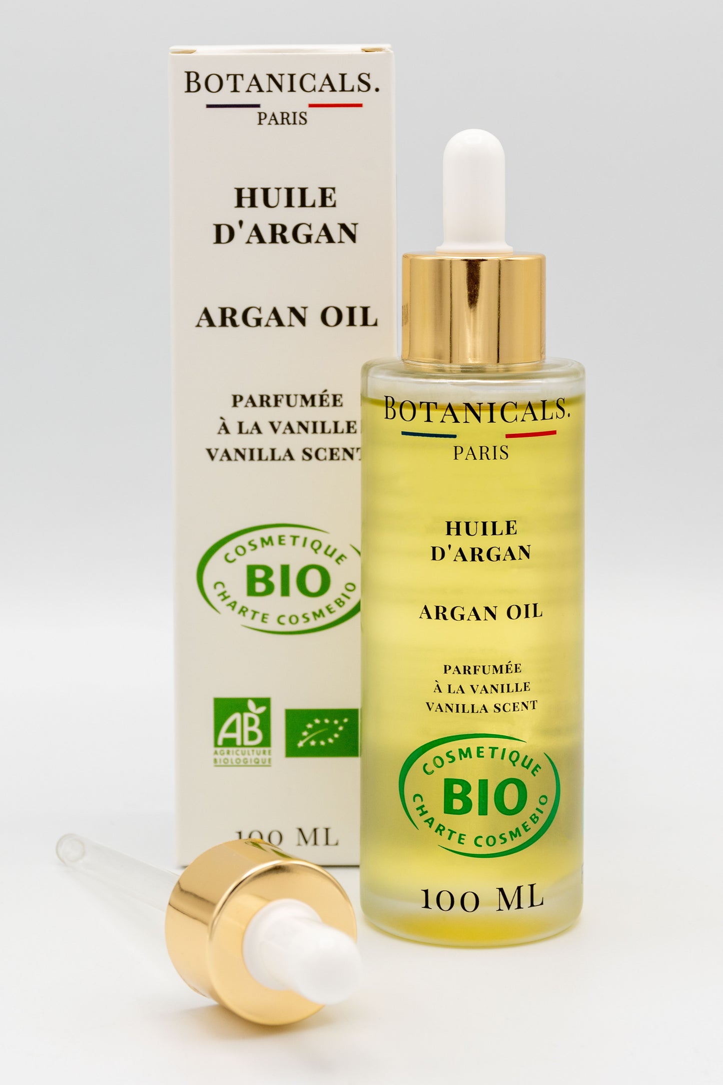 Une bouteille d'huile d'argan bio 100ml Botanicals devant sa boite, une pipette posé devant
