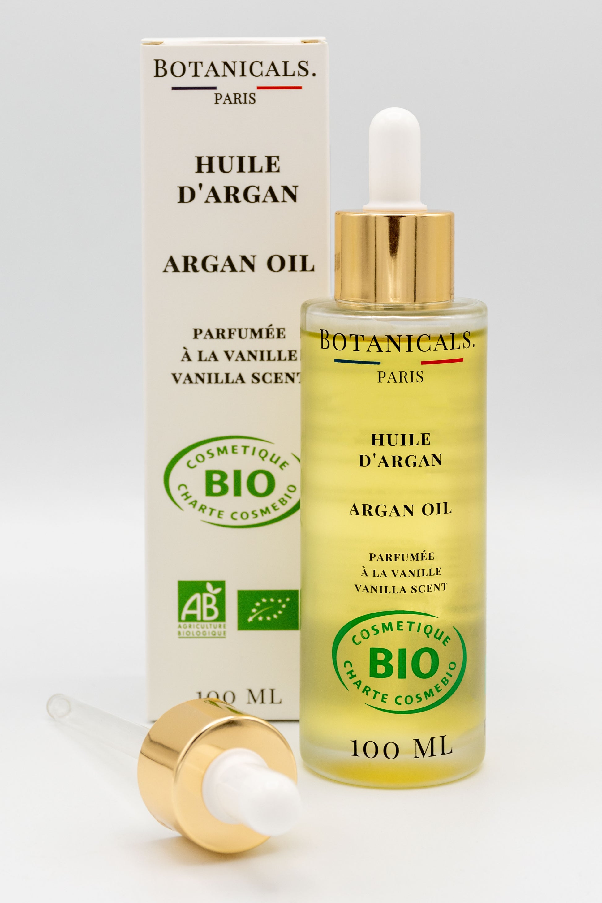 Une bouteille d'huile d'argan bio 100ml Botanicals devant sa boite, une pipette posé devant