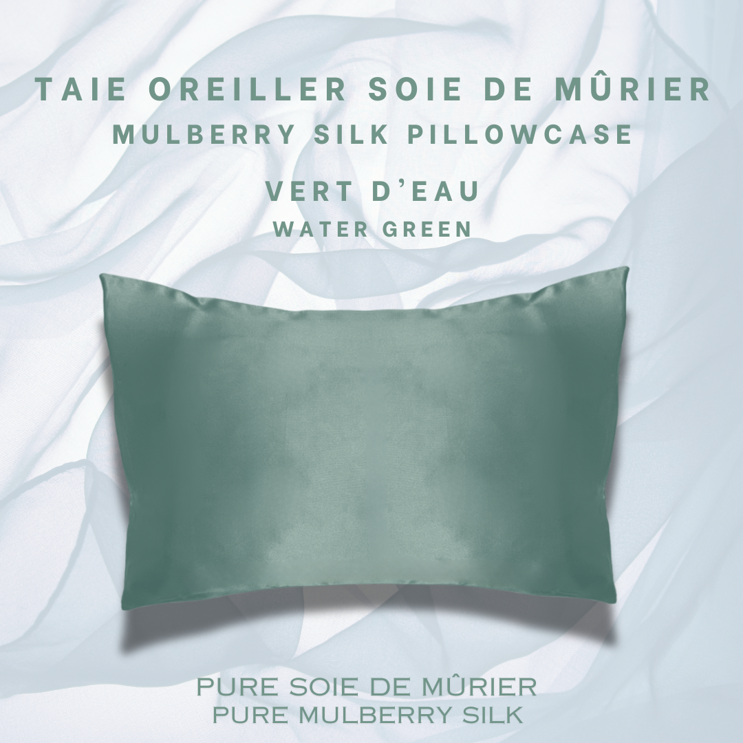 Un oreiller habillé d'une magnifique taie d'oreiller en soie de murier vert d'eau